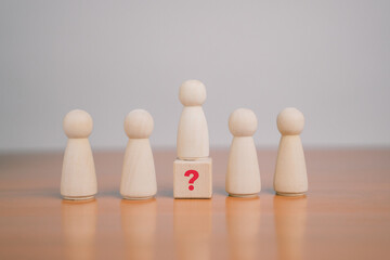 What do the wooden blocks in the question mark on the table mean? Teamwork concept, business,...