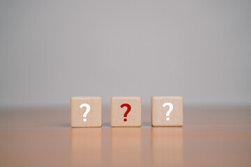 What do the wooden blocks in the question mark on the table mean? Teamwork concept, business,...