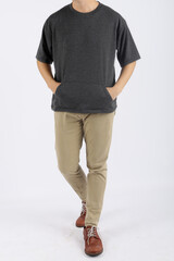 Obraz premium Young man wearing a t-shirt with pockets on the front, and wearing long pants and leather shoes