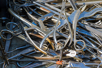 Large pile of used metal scissors medical waste dumped on landslide