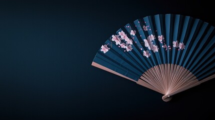 A decorative hand fan with cherry blossom designs on a dark blue background.