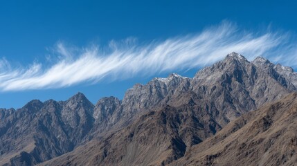 Serene Mountain Landscape with Clouds and Blue Sky Over Peaks