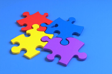 Obraz premium four colorful puzzle pieces on a blue background