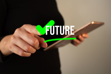 Fototapeta premium Woman holding a tablet while pointing at a button with a green check mark with the word future