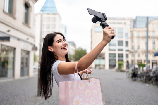 Mixed race woman traveler use camera record vlog while travel in city. 