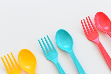 colorful spoon and fork isolated on white background, plastic cutlery for picnic