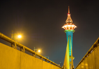 The tall pillar of the bridge over the river are beautifully decorated with lights at night