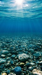 Sunlit underwater scene of a rocky bottom Sunlight beams through the clear water