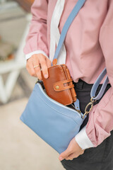 A bluish gray leather shoulder bag with a girl's model
