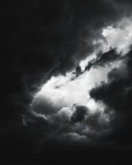 Obraz premium Dramatic monochrome sky with dark storm clouds and bright opening overhead in a moody vertical shot