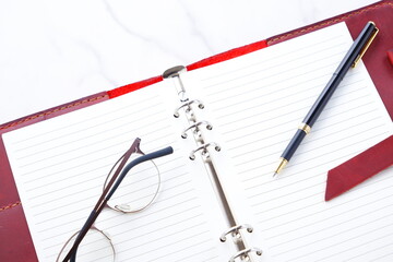 Opened Organizer with Pen on Table
