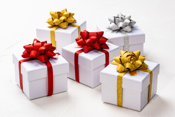 白背景に並ぶカラフルなリボンのギフトボックス