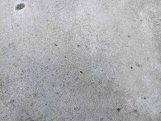 Rough Gray Cement Surface with Natural Marks and Dust. Textured gray concrete surface with subtle stains and small cracks, perfect for industrial or grunge-style background use