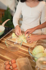 Smiling mother and daughter preparing a healthy meal together in a cozy kitchen at home