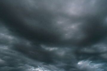 Obraz premium Dramatic dark storm thundercloud rain clouds on black sky background. Dark thunderstorm clouds rainny landscape. Meteorology danger windstorm disaster climate. Dark cloudscape storm disaster gray sky