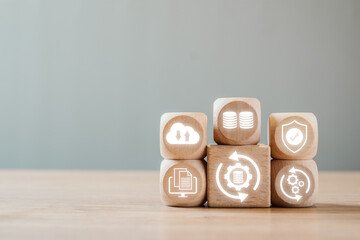 Wooden blocks with icons representing data backup, cloud storage, and security on a wooden surface.