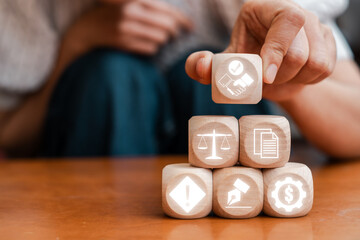 Wooden blocks with icons representing business contracts, legal agreements, and financial transactions in a professional setting.