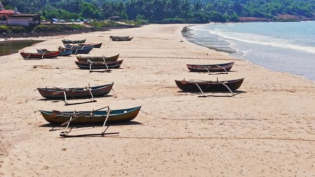 Aerial view over traditional Dhoni fishing vessels, moored on a beach in India