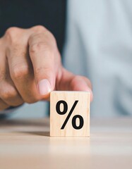 A person carefully positions a large, bold number seventy atop a smooth, polished wooden block, showcasing a creative display in a bright, airy setting.