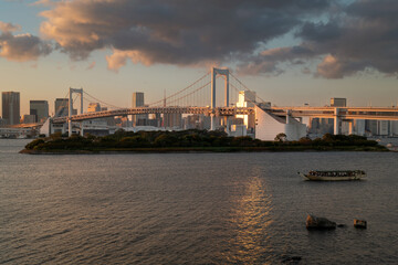 Obraz premium View of the automobile suspension Bridge over the North Tokyo Bay Rainbow Bridge from Odaiba Island at sunset, Tokyo, Japan