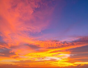 Fototapeta premium A breathtaking sunset casts vibrant hues of orange, pink, and purple across the sky, reflecting on the calm ocean waters, with fluffy clouds adding depth.