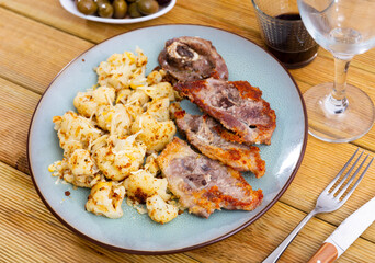 Plate of fried lamb and cauliflower stew on a beautifully set table