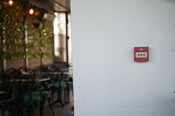 Vintage fire alarm on a wall in a bustling restaurant setting