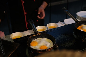 Cooking eggs stove Delicious fried eggs with bacon and tomatoes in pan on stove, top view