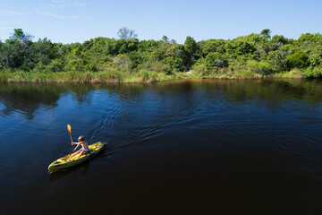 Happy active kids have a fun on yellow kayak in sea lagoon. Healthy lifestyle. Recreational water sport, kayaking tour in adventure camp on family summer beach vacation