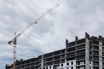 An unfinished skyscraper against a cloudy sky.