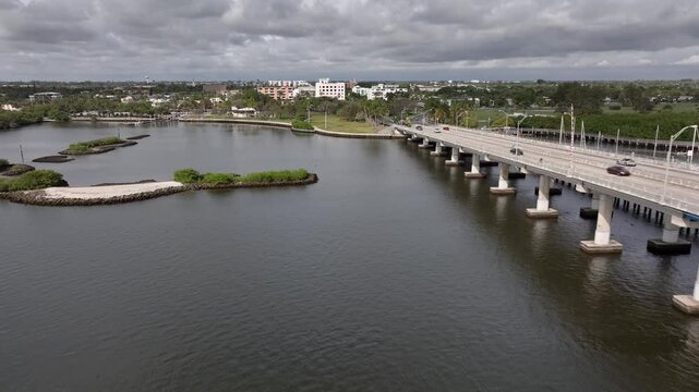 Drone flying west over the intracoastal waterway next to the drawbridge and approaching Lake Worth Beach Florida on a cloudy overcast day