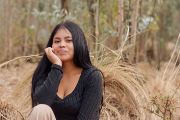 Young latin woman posing in nature with hand on chin