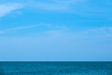 Obraz premium Nature of the ocean and blue sky Summer with sunshine, sandy beaches, clear blue waters sparkling against the blue sky. on an island with good ecology and environment Background for summer vacation