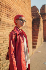 Fototapeta premium Gen z girl leather fashion with punk Asian woman tourist of local city Southeast Asia travel trendy pink hairstyle young female punk traveler walking around in town