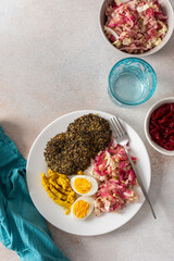 A nutritious breakfast featuring quinoa pancakes, fresh cabbage, radish, mung bean sprouts, boiled eggs, hummus, and roasted beets, perfect for a balanced start to your day