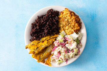 A wholesome and savory breakfast with brown rice and baked white fish, complemented by zucchini-carrot pancakes and a fresh Chinese cabbage salad with radish