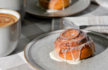 Cinnamon rolls on plates with coffee