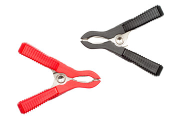 Black and red electrical clips on a white background. Alligator clips to charge the battery.