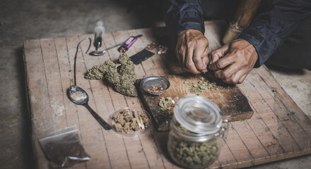 A person man sits alone in a dark room smoking marijuana, Drug addict man or drug dealer prepares...