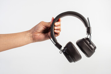 HeadPhones in hand, Headphones isolate on white. Wireless headphones in brown.