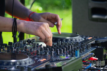 DJ Hands creating and regulating music on dj console mixer in concert outdoor