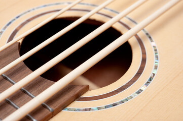 Four-string bass ukulele with wooden body and built-in tuner and pickup.