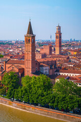 Verona city skyline, church towers, traditional houses, and bridges tracing the curving Adige River in Veneto, Italy—a tranquil metropolitan landscape seen from Piazzale Castel San Pietro hilltop.