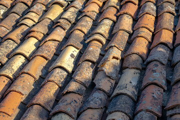 Roofing, waterproofing. Surface. Old worn tiles. Building material background. Red tiles that require maintenance. Top view, above.	