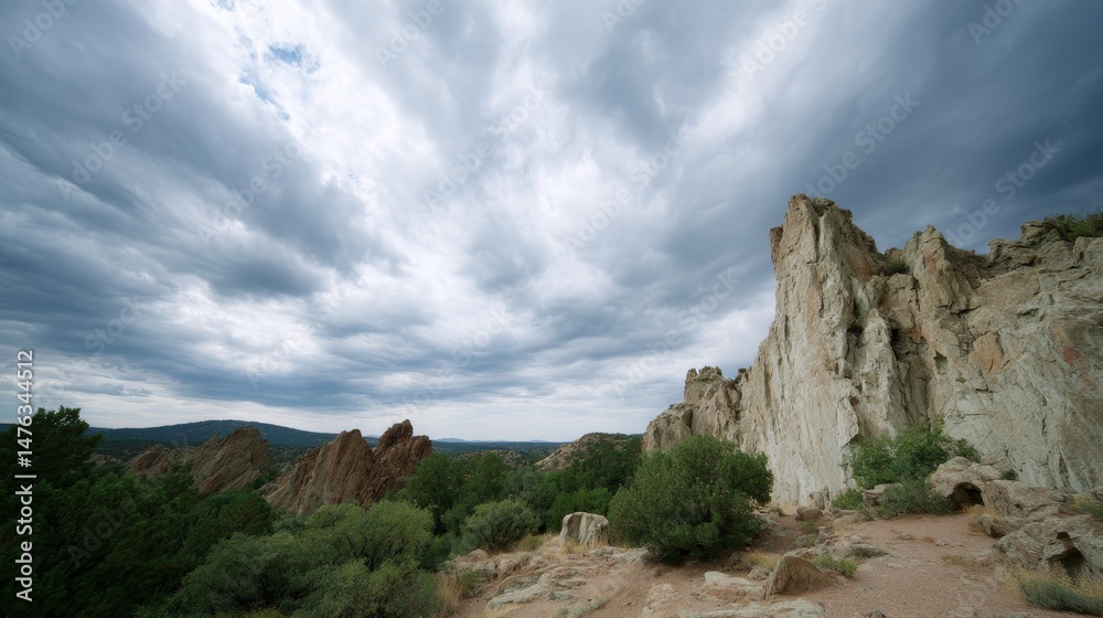 Poster jagged cliffs rise dramatically against a backdrop of swirling gray clouds, capturing the essence of