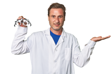A middle-aged optometrist man showing a copy space on a palm and holding another hand on waist.