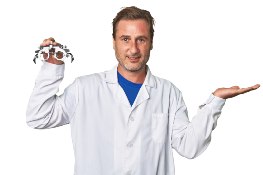A middle-aged optometrist man showing a copy space on a palm and holding another hand on waist.