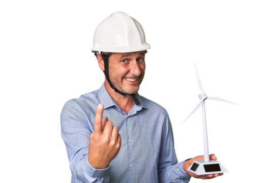 A middle-aged architect man holding a windmill model pointing with finger at you as if inviting come closer.