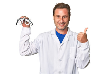 Experienced optometrist conducts eye exam with care, holding prescription glasses.