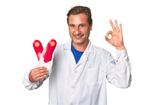 A middle-aged podiatrist holding an insoles